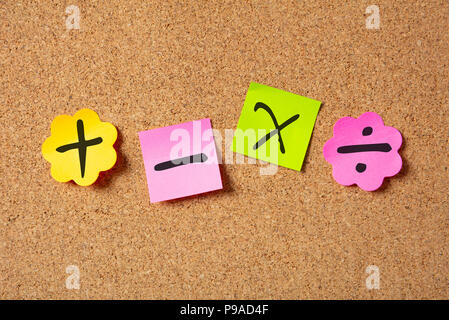 Scuola di concetto di matematica. Sticky note colorate a forma di fiore isolato con i simboli matematici sulla bacheca di sughero dello sfondo. Foto Stock