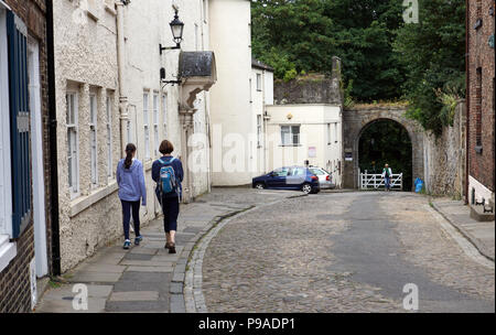 Persone che camminano giù una vecchia strada di ciottoli passato vittoriana di vecchie case terrazza nella parte vecchia della città di Durham Inghilterra Foto Stock