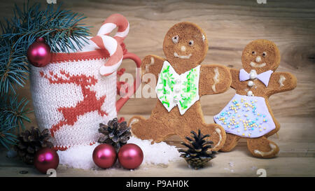 Bella tazza di Natale e gingerbread man sul tavolo di legno Foto Stock