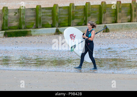 Hastings, East Sussex, Regno Unito. 17 lug 2018. Regno Unito Meteo: caldo e soleggiato in Hastings, East Sussex con nuvole intermittente ma una brezza di benvenuto nell'aria. Un sacco di persone stanno godendo della prolungata ondata di caldo continua a colpire la Gran Bretagna. Le temperature sono dovrebbe superare 25°C. Una racchetta boarder capi al mare per godere la calma le onde. Photo credit: Paolo Lawrenson / Alamy Live News Foto Stock