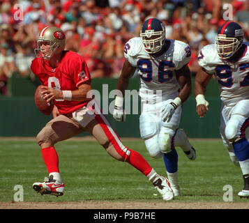 San Francisco, California, Stati Uniti d'America. 1° Ott, 1995. San Francisco 49ers vs. New York Giants al Candlestick Park domenica 1 ottobre 1995. 49ers battere giganti 20-6. San Francisco 49ers Quarterback Steve giovani (8) si allontana da New York Giants difensivo fine Jamal Duff (96) difensiva e affrontare Robert Harris: credito al Golub/ZUMA filo/Alamy Live News Foto Stock