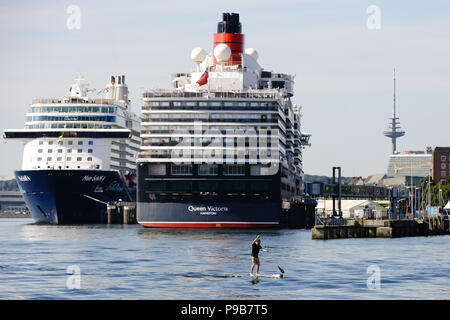 Kiel, Germania. 17 Luglio, 2018. La Cunard cruiser "Queen Victoria" (R) docks per la prima volta presso il porto di Kiel. La compagnia di navigazione marittima che accompagna il primo aggancio della "Queen Elisabeth' nave gemella con un programma festivo come pure un 'Champagne Tea Time' su un 70-metro-lungo divano. Credito: Frank Molter/dpa/Alamy Live News Foto Stock