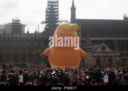 'STOP TRUMP' marcia di protesta in piazza del Parlamento giardini come un arrabbiato caricatura del presidente Donald Trump affacciata alla folla. Londra, UK 13/7/18. Foto Stock