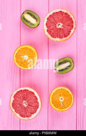 Assortimento di agrumi, vista dall'alto. Tagliate freschi Pompelmi e pomeli, arance e kiwi rosa su sfondo di legno. Ricco di vitamina C. Foto Stock