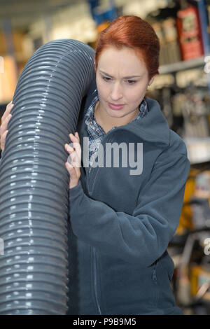 Elettricista femmina che porta bobina Foto Stock