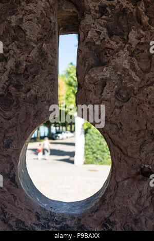 Muro di calcestruzzo medievil foro guardare attraverso con le persone Foto Stock