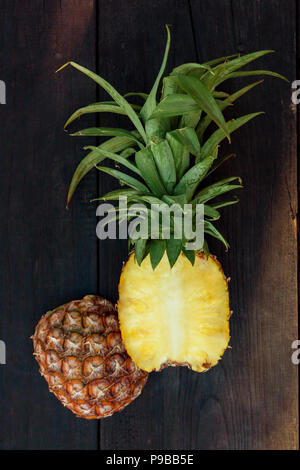 Ananas fresco tagliato a metà dal di sopra su un tavolo di legno. Foto Stock