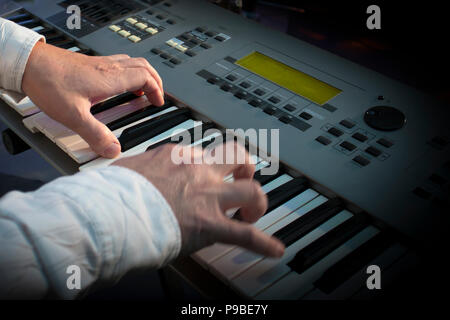 Primo piano delle mani del musicista sintetizzatore di riproduzione in concerto Foto Stock