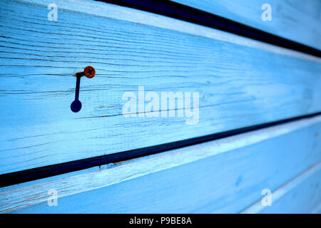 Pareti in legno di colore blu tavole dipinte con singolo rusty intasato vite, può essere utilizzato come sfondo Foto Stock