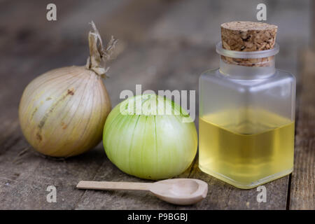 Onion succo di frutta e verdura su un tavolo di legno. Fatti in casa a base di sciroppo per il trattamento dell'influenza. Sfondo scuro. Foto Stock