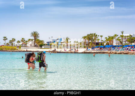 AYIA NAPA, Cipro - 07 Aprile 2018: Backpackers camminando sulla spiaggia di Nissi Foto Stock