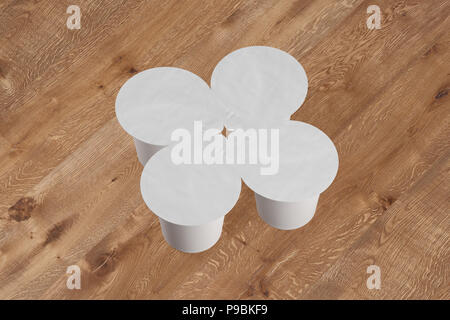 Confezione vuota di quattro yogurt bianco di imballaggio. Mockup dessert contenitore in plastica isolato su sfondo di legno con percorso di clipping. 3D render Foto Stock