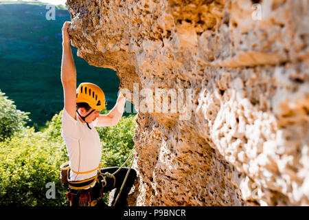 Immagine dell uomo nel casco salire sulla montagna Foto Stock