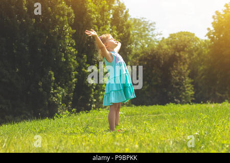 Bambina nel parco con le braccia aperte; concetto LIFE Foto Stock