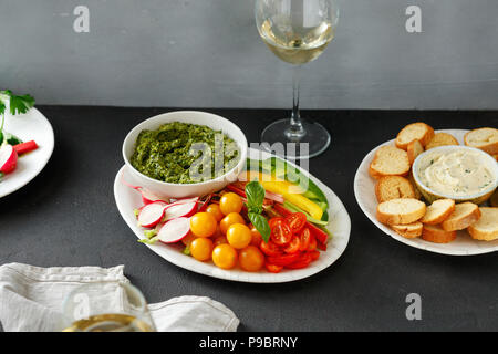 Verdure crude, crostini di pane con il pesto e salsa di aglio con vino bianco. Snack sani per i vini Foto Stock