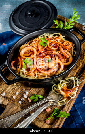 Cucina Italiana, Calamari Fra Diavolo, spaghetti marinara con pesce e frutti di mare, il fondo azzurro spazio copia vista superiore Foto Stock