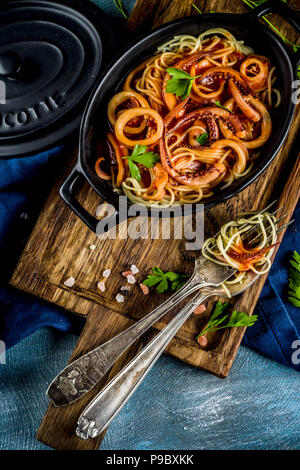 Cucina Italiana, Calamari Fra Diavolo, spaghetti marinara con pesce e frutti di mare, il fondo azzurro spazio copia vista superiore Foto Stock