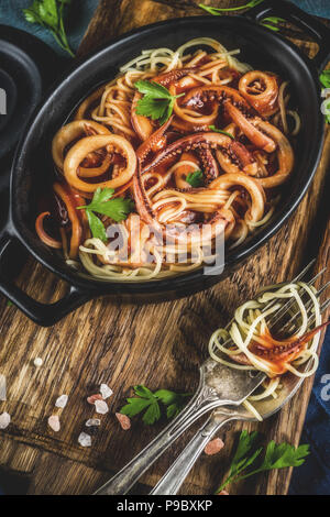 Cucina Italiana, Calamari Fra Diavolo, spaghetti marinara con pesce e frutti di mare, il fondo azzurro spazio copia vista superiore Foto Stock