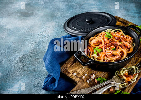 Cucina Italiana, Calamari Fra Diavolo, spaghetti marinara con pesce e frutti di mare, il fondo azzurro spazio copia vista superiore Foto Stock