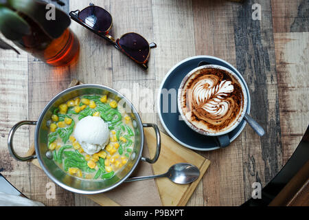 Vista superiore Lod Chong, un Thai dessert tradizionale di pandan aromatizzati farina di riso goccioline in noce di cocco zuccherati lo sciroppo di crema di riso tagliatelle fatte di riso mangiare Foto Stock