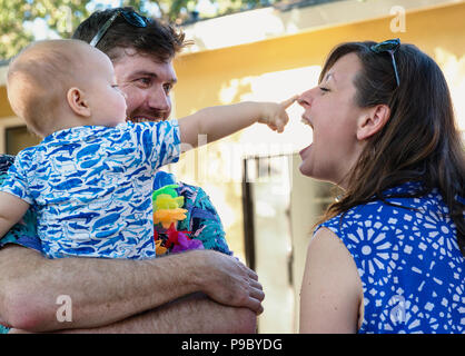 I genitori e i loro bambini appendere fuori a una parte del cortile. Foto Stock