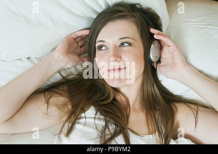 Una donna che indossa le cuffie. Foto Stock