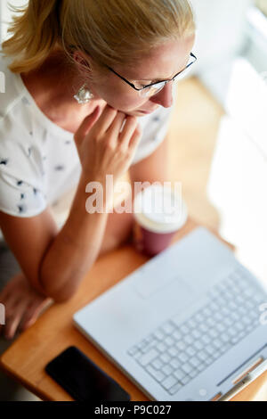 Donna che utilizza laptop online Foto Stock