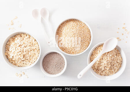 Varietà di materie dei cereali per la prima colazione. Fiocchi di avena e di acciaio tagliati, orzo, chia. Ingredienti sani Foto Stock