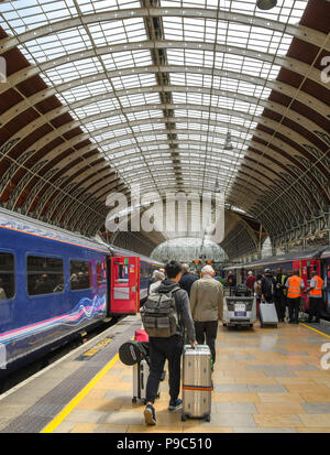 Passeggeri a piedi lungo una piattaforma a Londra Paddington railway station dopo aver spento il loro treno Foto Stock