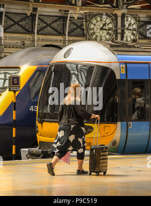 Il passeggero a piedi lungo una piattaforma a Londra la stazione ferroviaria di Paddington a bordo del treno Heathrow Express Foto Stock