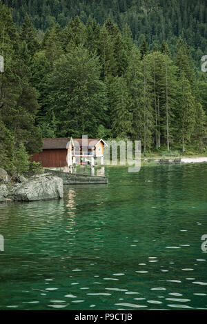 Piccola casetta sul lago sul lato del lago Eibsee nelle Alpi bavaresi, Baviera, Germania Foto Stock