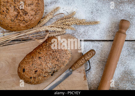 Seminate il pane su una scheda di pane di grano e di un coltello per pane. Regno Unito Foto Stock