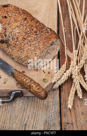 Seminate il pane su una scheda di pane di grano e di un coltello per pane. Regno Unito Foto Stock