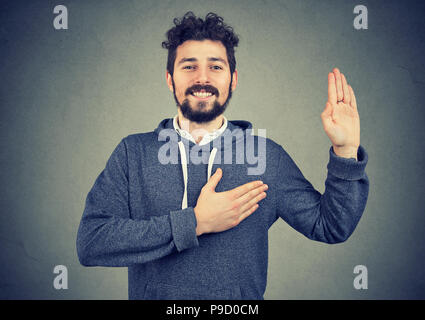 Giovane uomo bello fare una promessa Foto Stock