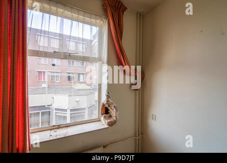 Tende rosse appese in edificio abbandonato presto per essere demolita Foto Stock