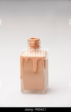 Una bottiglia di vetro e una base liquida che viene tracciata su di esso Foto Stock