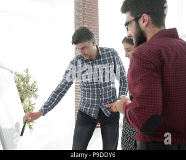 Felice l'Uomo in camicia a scacchi in piedi in ufficio nei pressi di lavagna a fogli mobili Foto Stock