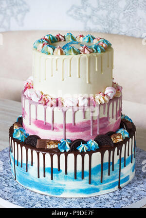 Tre livelli torta colorata con macchie colorate di cioccolato su uno sfondo luminoso. Immagine di un menu o di un catalogo di prodotti dolciari con spazio di copia Foto Stock