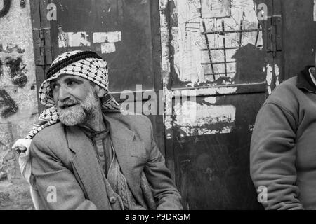 Due uomini palestinesi sono seduti avente una chat un zigarettes nella parte vecchia della città di Hebron og che recano insediamenti illegali dalle truppe Isra Foto Stock