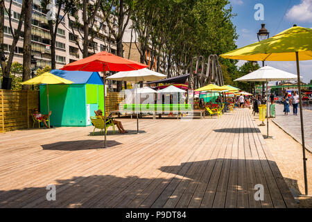 Colorato ombrelloni da spiaggia al Paris Plages in una calda giornata estiva presso il Bassin de la Villette a Parigi, Francia Foto Stock