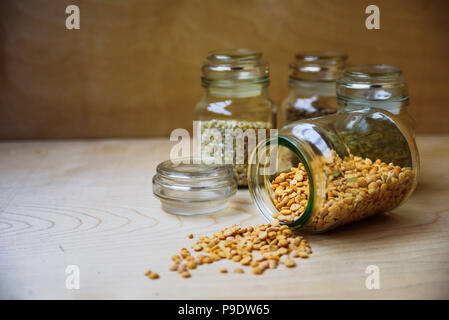 Piselli secchi nel vasetto di vetro nei pressi di fagioli, riso e orzo perlato Foto Stock