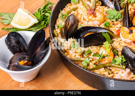 La cucina spagnola paella con pesce e verdure Foto Stock