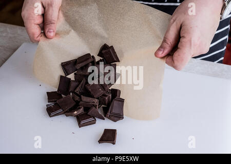 Un cuoco pesati con pezzetti di cioccolato sulla carta oleata. Foto Stock