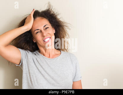 Capelli arricciati donna brasiliana ha sottolineato con la mano sulla testa, sconvolto con vergogna e la sorpresa di fronte, arrabbiati e frustrati. Paura e sconvolti per l'errore. Foto Stock