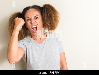 Donna brasiliana indossando pigtail infastiditi e frustrato grida con rabbia, crazy e urla con la mano alzata, concetto di rabbia Foto Stock