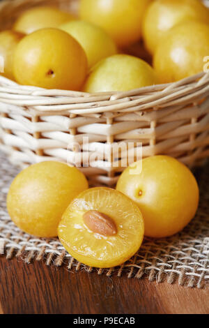 Giallo ciliegia prugne noto anche come mirabelle prugne in cesto tessuto Foto Stock