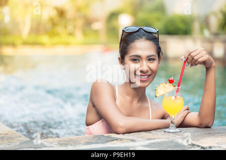 Ritratto di una bella donna asiatica di bere un cocktail di ananas Foto Stock