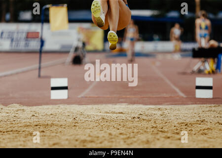Salto in lungo le gambe donna atleta ponticello competizione atletica Foto Stock
