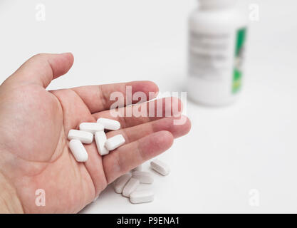 White pillole e medicinali in mano Foto Stock