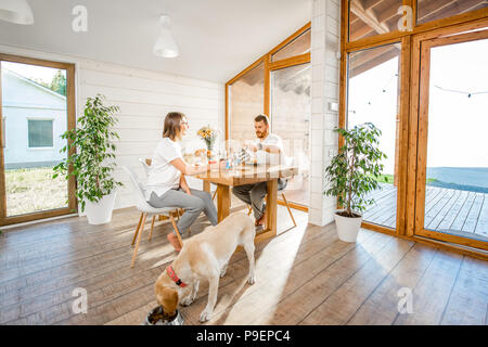 Cane con giovani della famiglia in casa Foto Stock